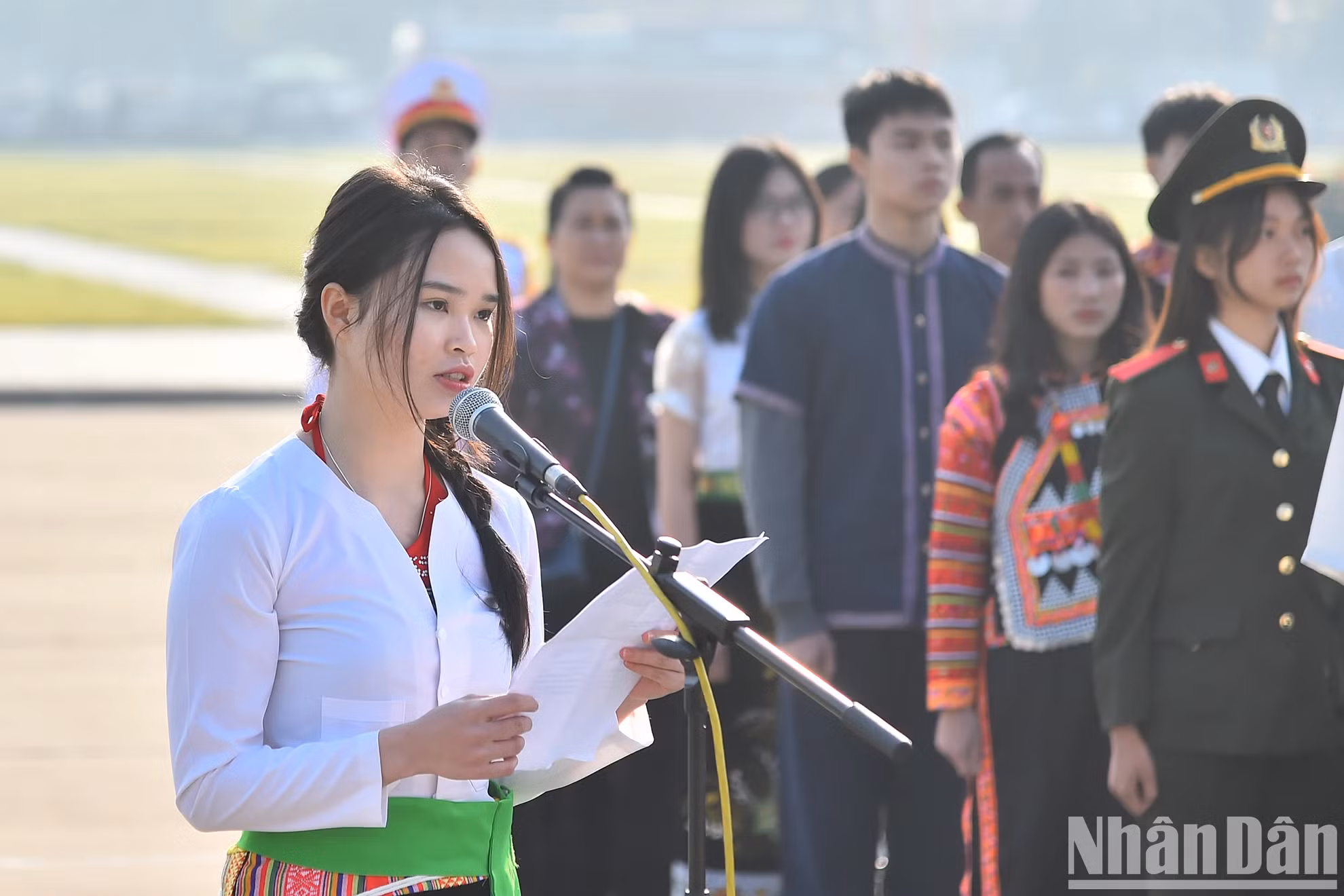 优秀少数民族学生和青年代表团代表阮氏芳草（芒族）在仪式上向胡伯伯报功。