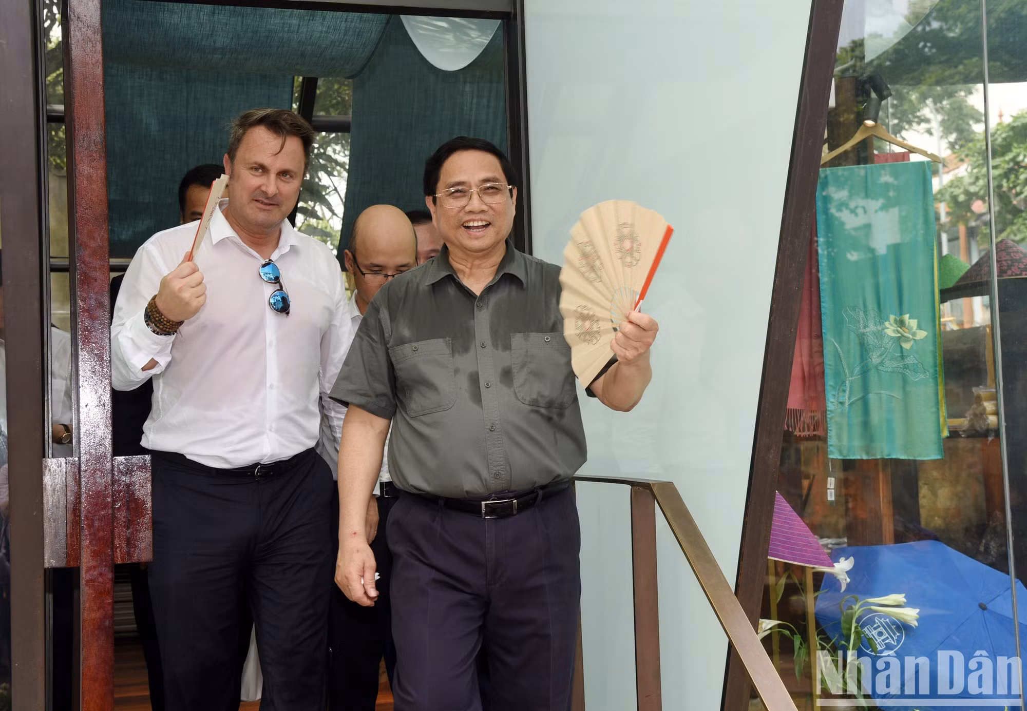 在初夏炎热的天气中，两位领导在文庙的一家纪念品店里买了两把小扇子。