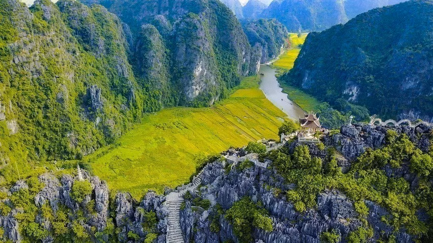 山顶有一尊观音佛像，而在山脚下梧桐河的河流蜿蜒绕行山间，让乘船的游客纷纷随着河流参观三个自然洞穴。（图片来源：越通社）