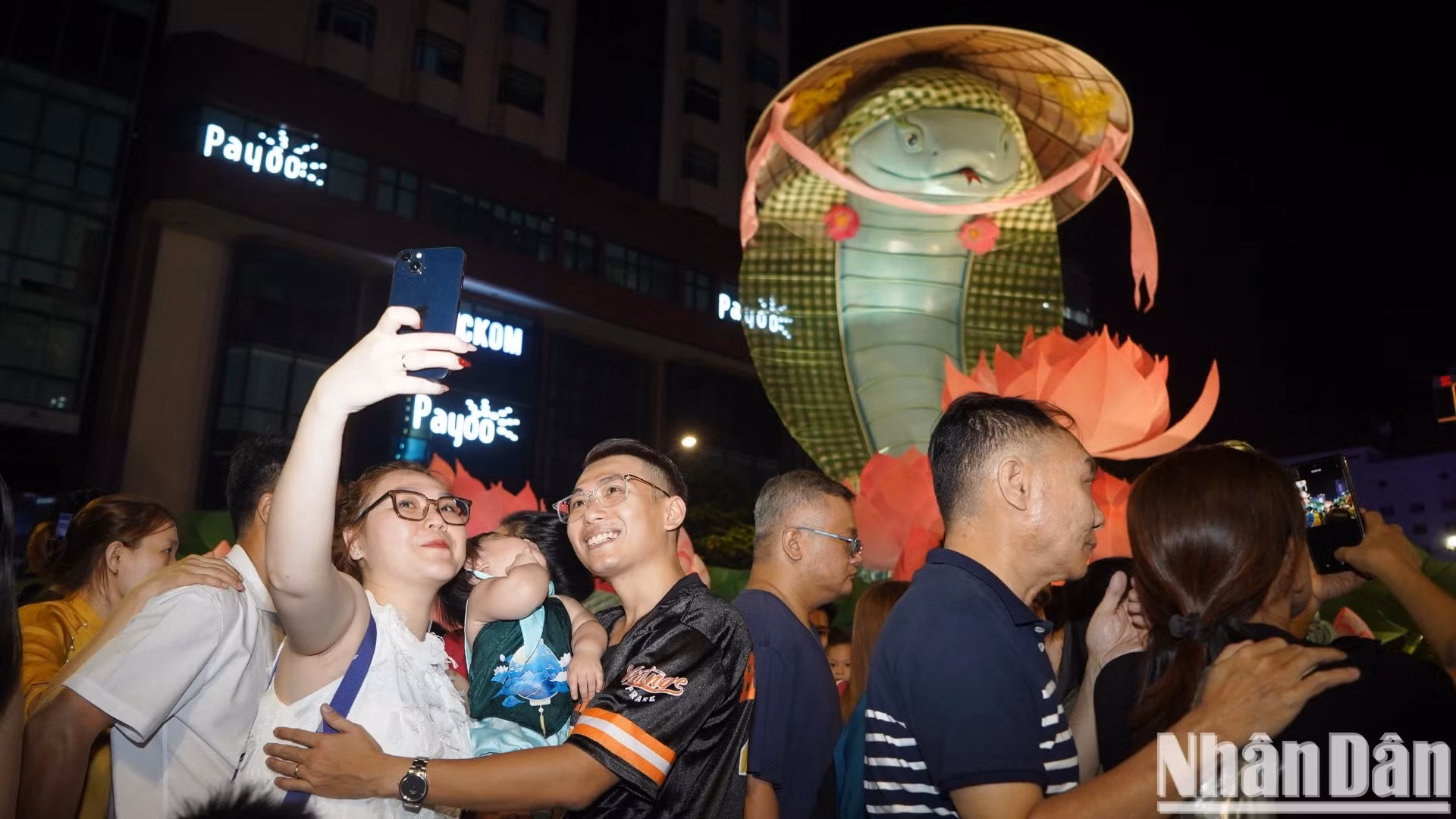 游客高兴地在2025乙巳年的吉祥物前拍照。