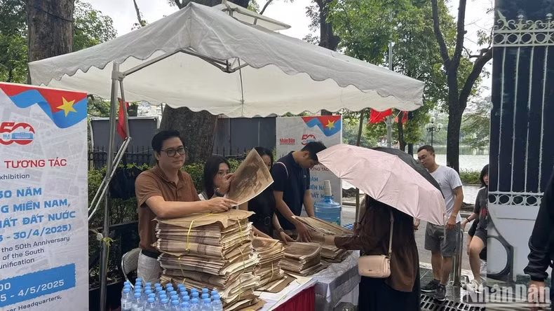 尽管下大雨，然而许多读者从一大早前来领取《人民报》特别副刊。