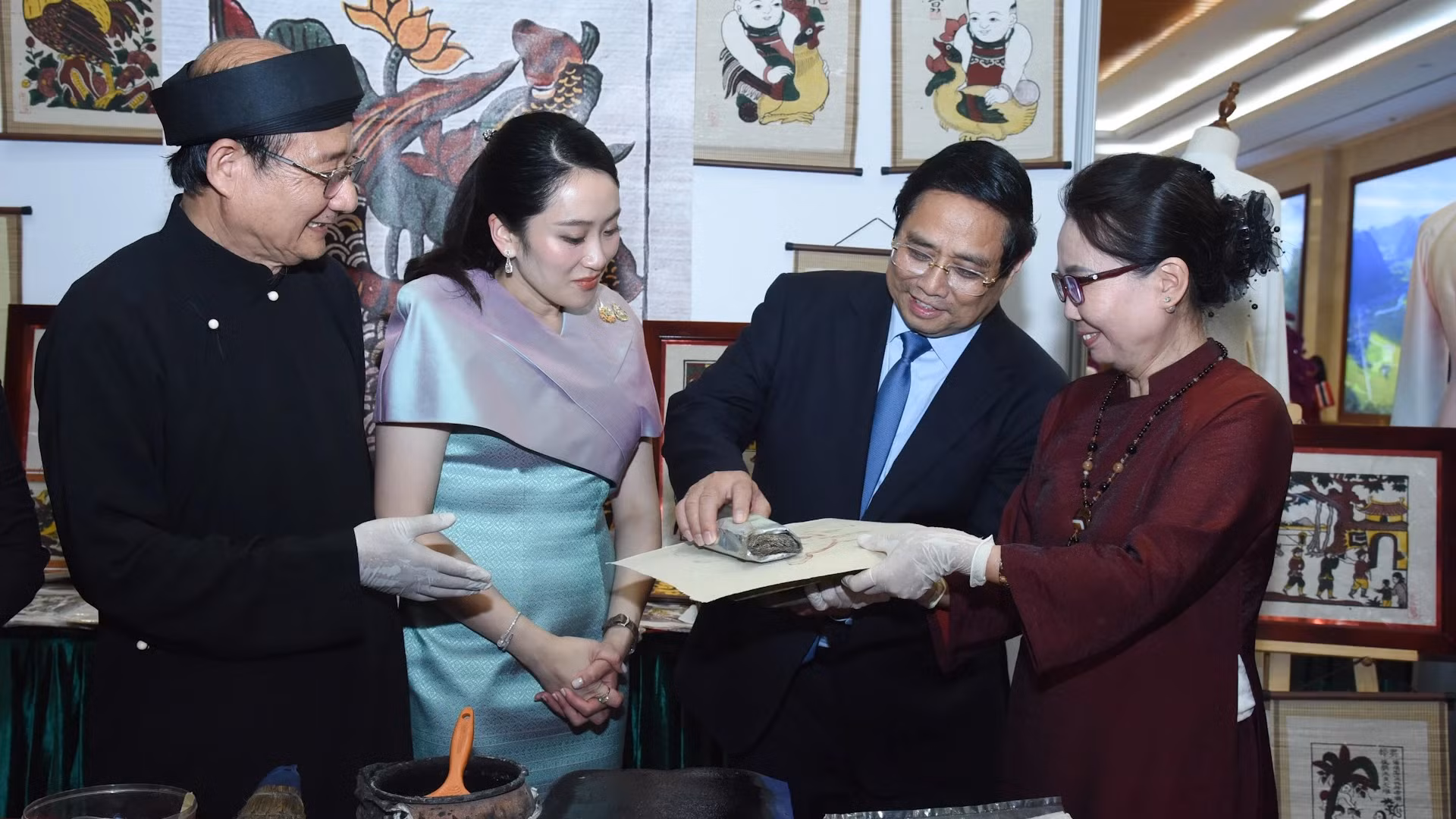 范明正总理与佩通坦总理共同体验东湖民间画制作技艺。