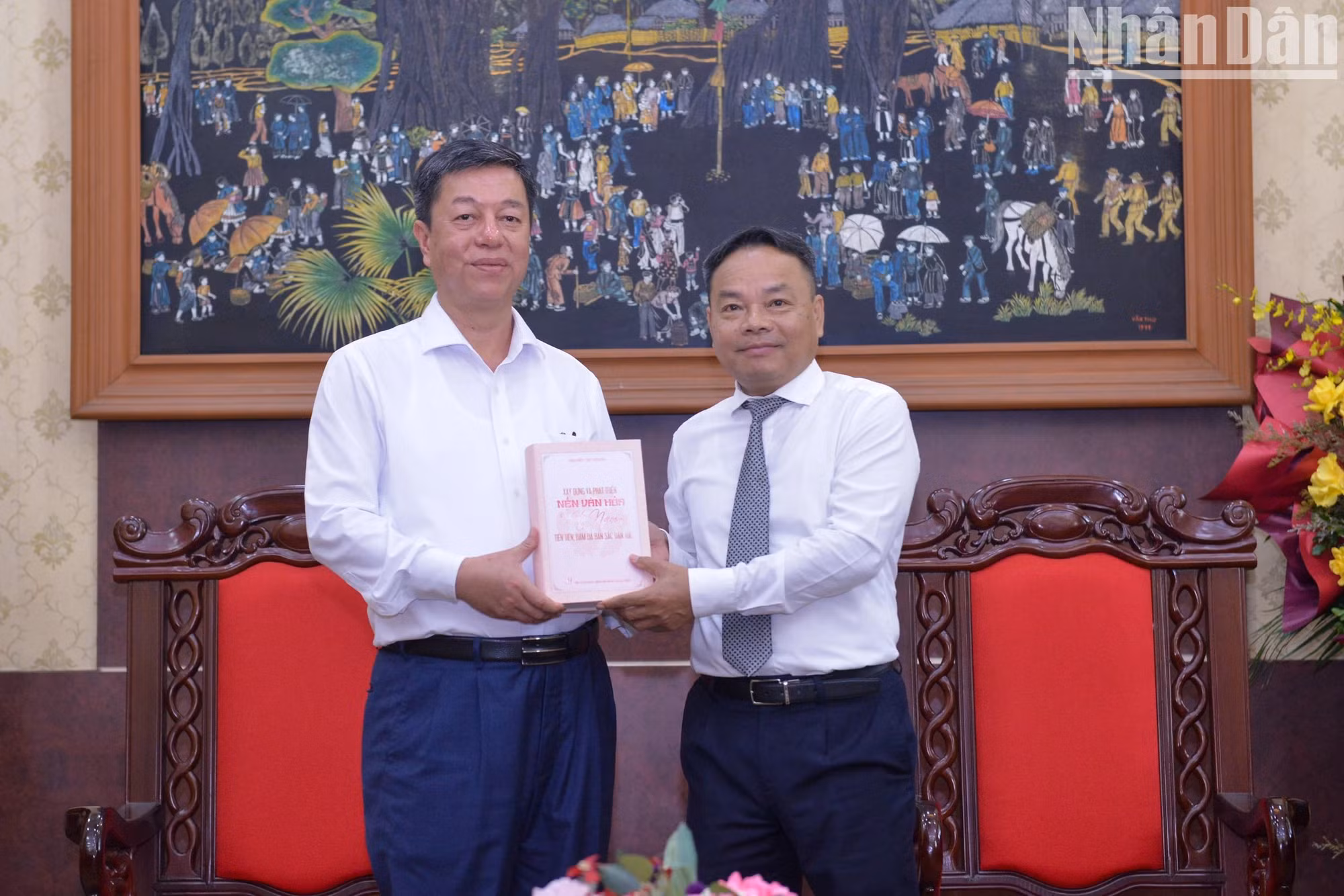 武仲林同志向《人民报》社副总编辑丁如欢赠送由越南真理国家政治出版社出版的书籍。（世大 摄）