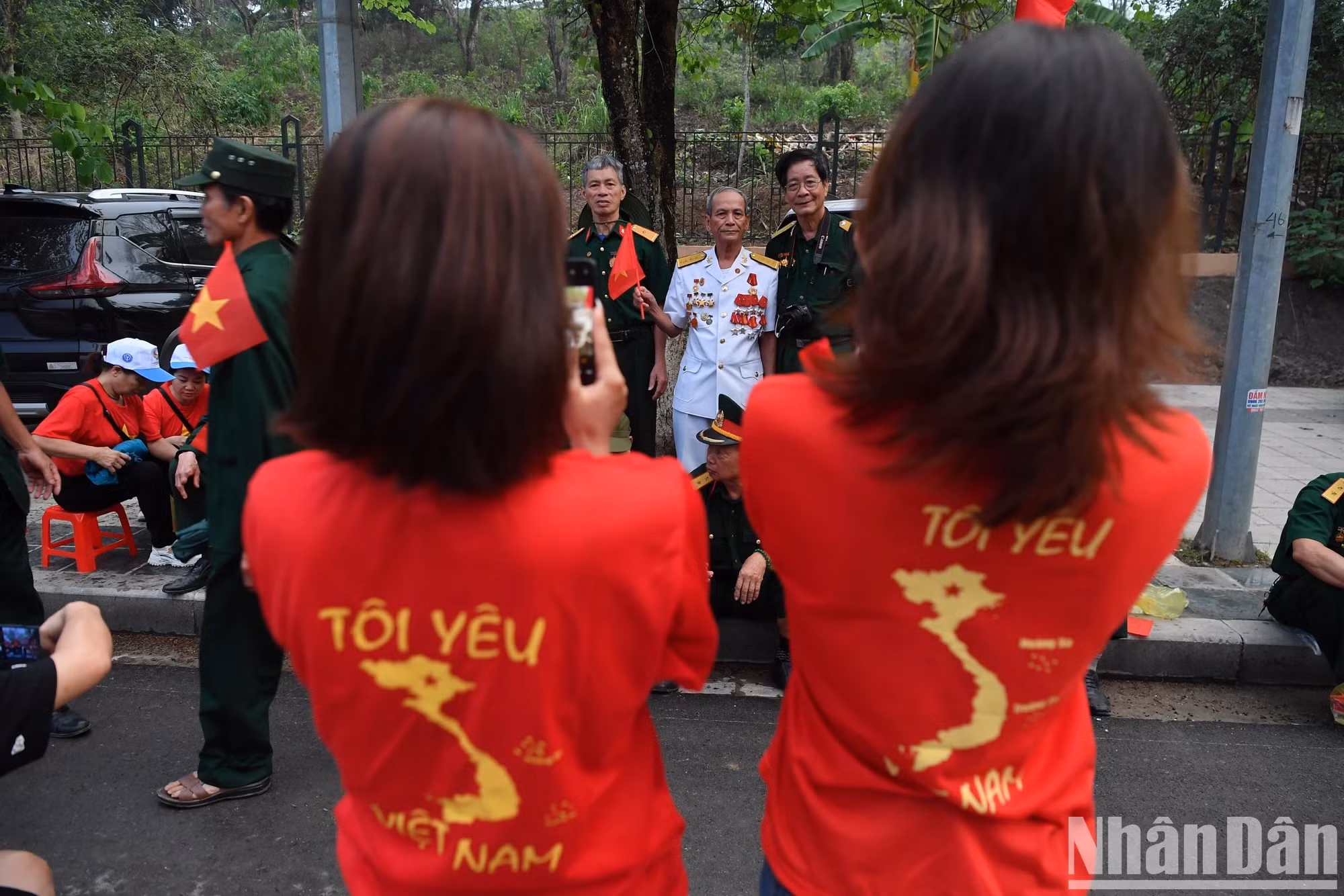年轻人穿着金星红旗的衣服，背后印有国家地图，写着“我爱越南”，展现民族自豪感。