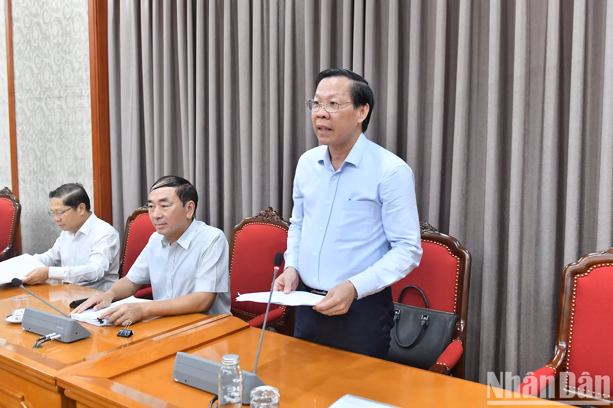 胡志明市人民委员会主席潘文买在会上作报告。