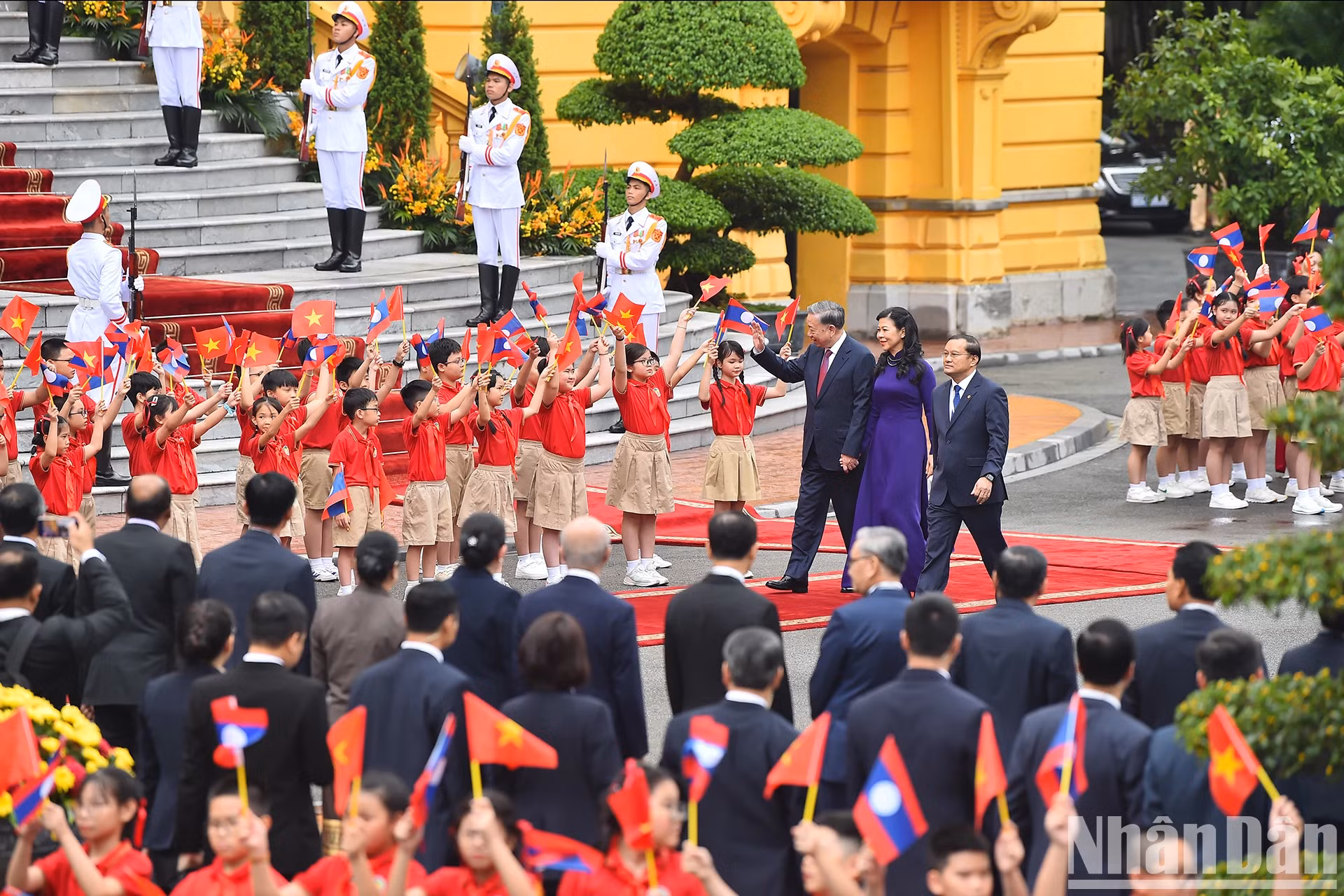 越共中央总书记、国家主席苏林和夫人向儿童们挥手。