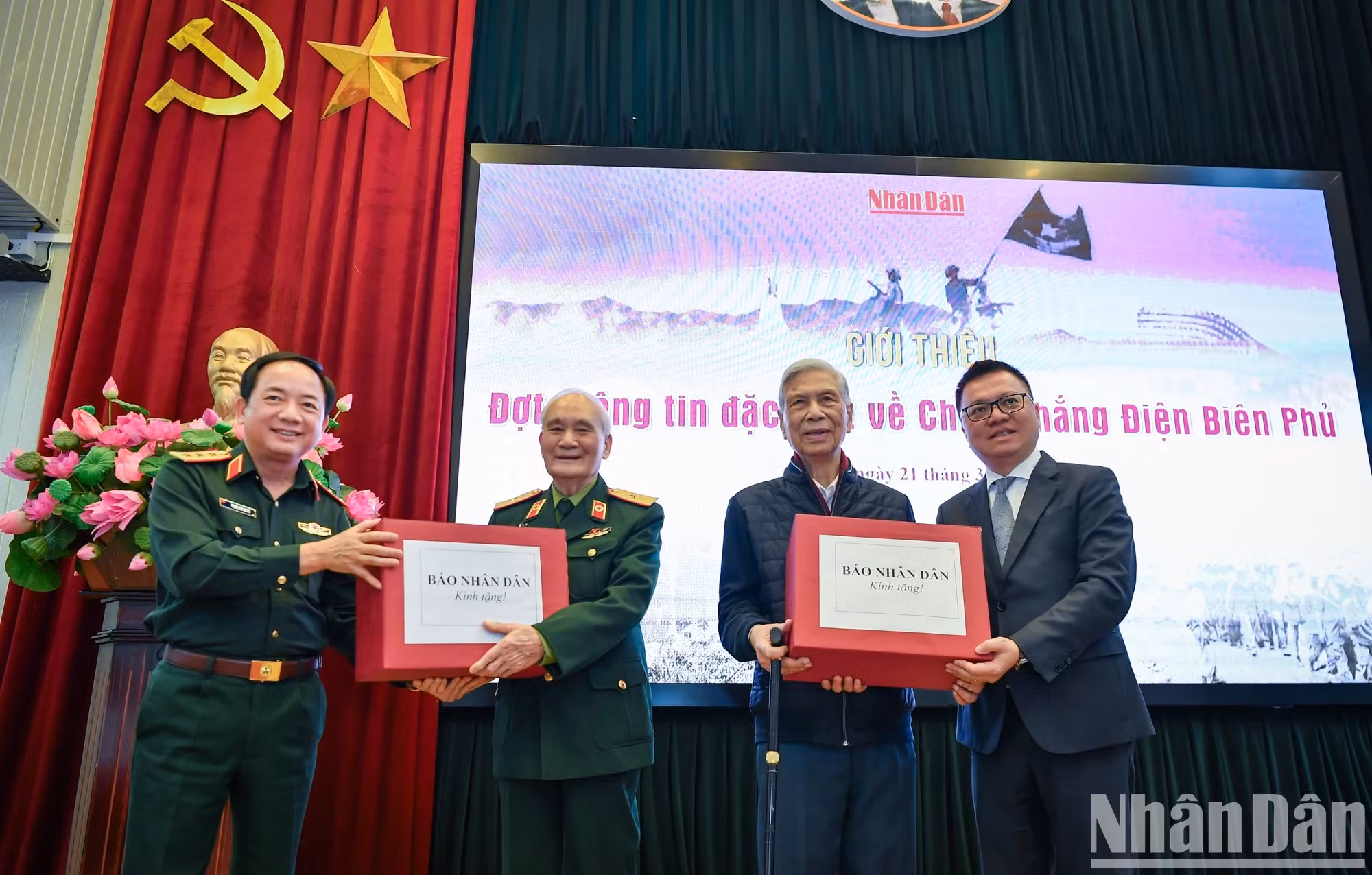 越南《人民报》社总编辑黎国明和越南人民军总政治局副主任郑文决向出席记者会的奠边府老战士赠送礼物。