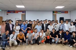 在昌原（韩国）的越南劳动者与各组织方和赞助方代表在提高昌原越南劳动者法律知识咨询会上合影留念。（图片来源：越通社）