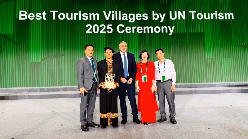 宣光省文化体育与旅游厅领导和倮倮寨旅游文化村村民接收“2025年世界最佳旅游乡村”称号。