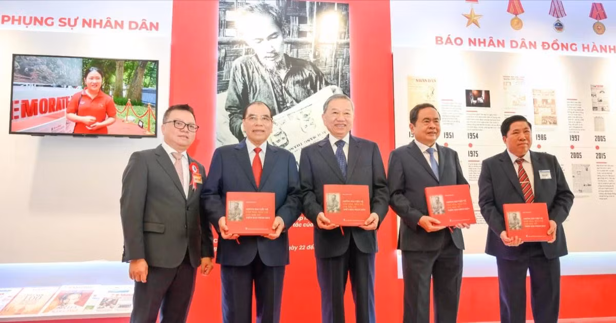 越共中央总书记苏林与党和国家领导同志及代表们在《人民报》社展区获赠《胡志明主席在〈人民报〉上发表的关于文化与新闻的文章选编》一书。