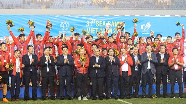 国家主席阮春福，政府总理范明正，国会主席王廷惠，越共中央书记处常务书记武文赏与越南U23足球队合影。（啸明 摄）