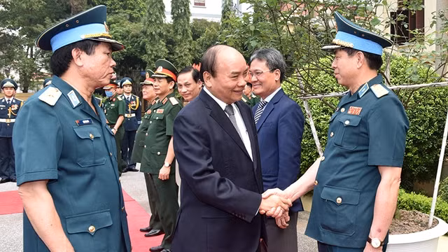 阮春福总理与越南防空空军军种司令部干部握手。（陈海 摄）