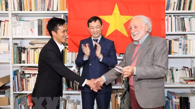 越意友好协会威内托大区分会主席达西向越南大学生代表交接在威尼斯越南文化屋。（图片来源：越通社）