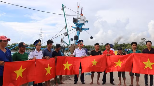 海警第四区司令部向坚江省安明县渔民赠送国旗。