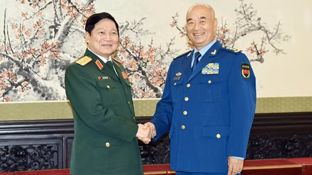 吴春历大将与许其亮上将亲切握手。（图片来源：越通社）