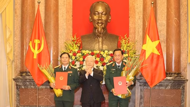 越共中央总书记、国家主席阮富仲向中将晋升上将军衔的军官颁发命令状。