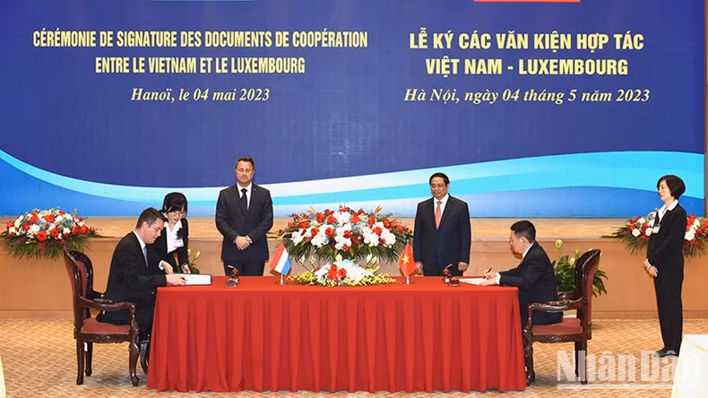 范明正总理和格扎维埃·贝泰尔首相共同见证两国金融领域合作文件的签字仪式。