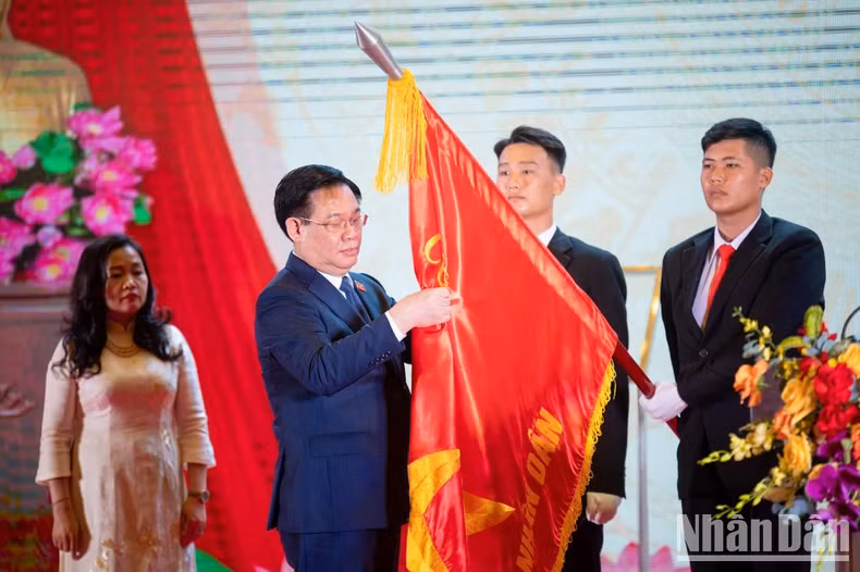 越南国会主席王廷惠将勋章佩戴在《人民代表报》社的传统旗帜上。
