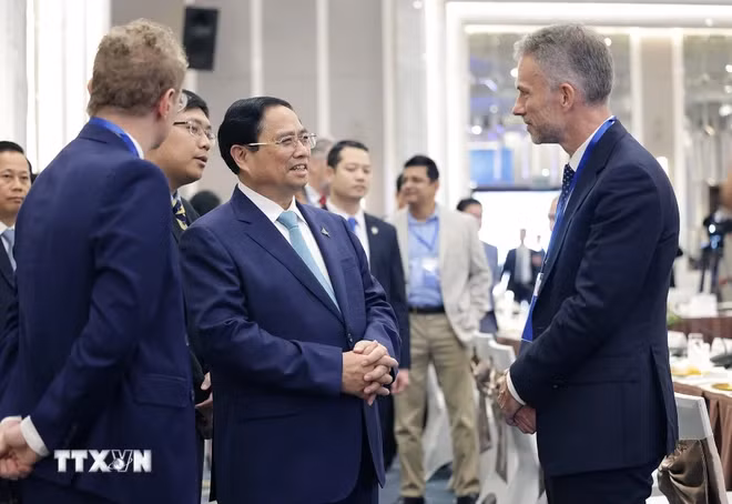 范明正总理与企业代表在会议间隙交流。