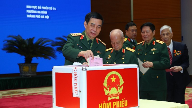 国防部部长潘文江大将和各位代表在河内市第14号投票区参加选举投票。