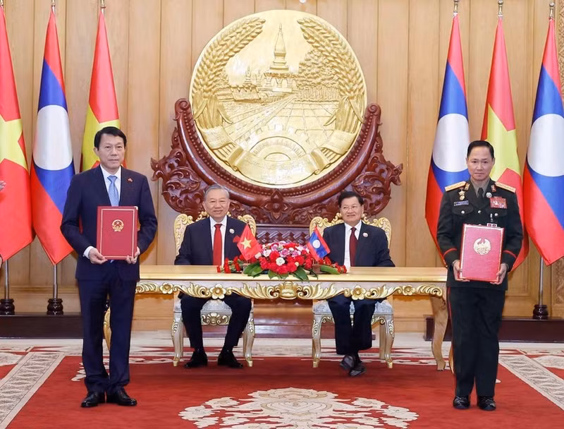 越共中央总书记苏林与老挝人民革命党中央总书记、国家主席通伦共同见证越南公安部与老挝国防部关于建设越老友谊道路项目的备忘录交换仪式。（图片来源：越通社）