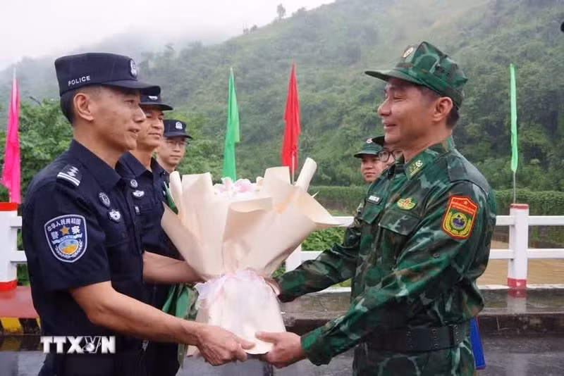 双方巡逻指挥长代表在越中边境友谊桥分界线上互相献花。（图片来源：越通社）