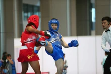 阮氏秋水（蓝衣）击败缅甸对手，夺得女子60公斤级散打金牌，为越南赢得当日首枚金牌。