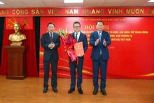 任命黎国明同志（中）为越南新闻工作者协会中央党委书记。