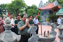 政府总理范明正在广治省向胡志明主席及英雄烈士敬香。（图片来源：越通社）