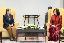 裴氏明怀同志（右）与柬埔寨祖国发展团结阵线国家委员会主席梅森安亲切交谈。