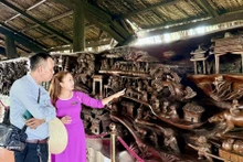 游客参观一幅长近25米、重约20吨的巨型流木画作。该画作被认为越南最为精工细作的作品之一。（图片来源：越通社）