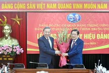 苏林总书记向潘廷镯同志颁发45年党龄纪念章。(登科 摄)