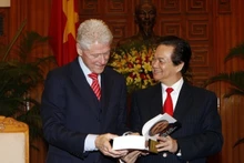 2010年11月14日，时任越南政府总理阮晋勇在河内向美国前总统比尔·克林顿赠送由越南公安部出版社出版的《我的人生：比尔·克林顿》一书。（图片来源：越通社）