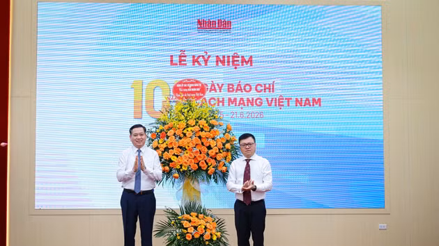 适值纪念越南革命新闻日101周年之际，越共中央党机关党委常务副书记阮龙海（左）向《人民报》社赠送鲜花表示祝贺。