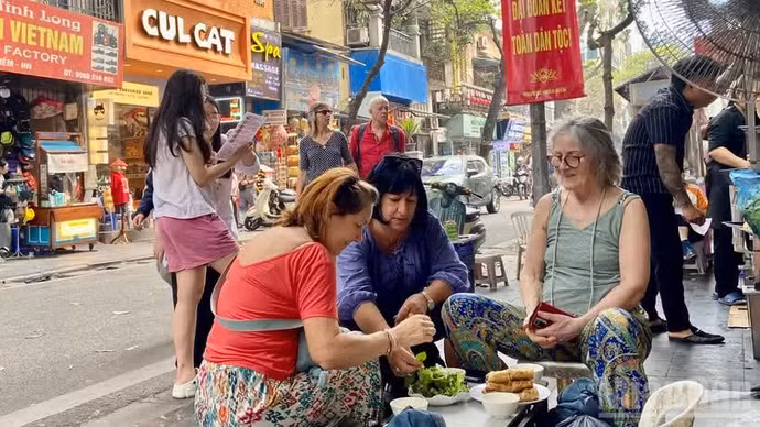 国际游客在游览河内时品尝街头美食。（昭英 摄） 