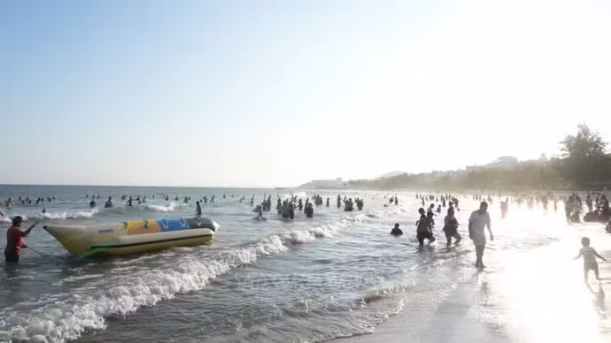 游客在美奈海边尽享清新的空气、湛蓝的海水和温暖明媚的阳光。