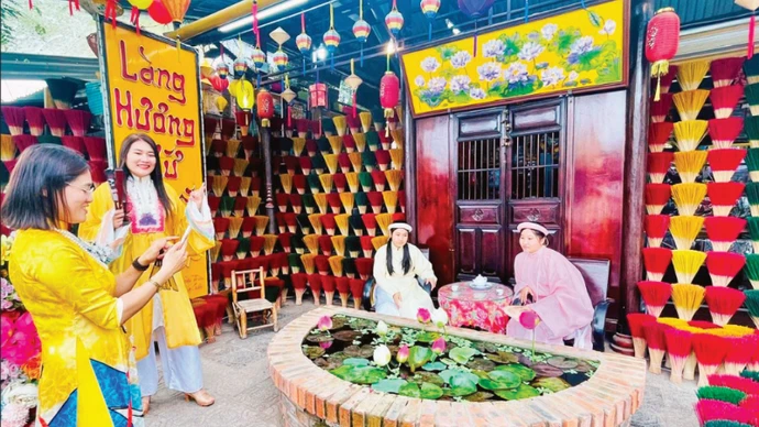 游客在顺化水春香村参观并体验活动。