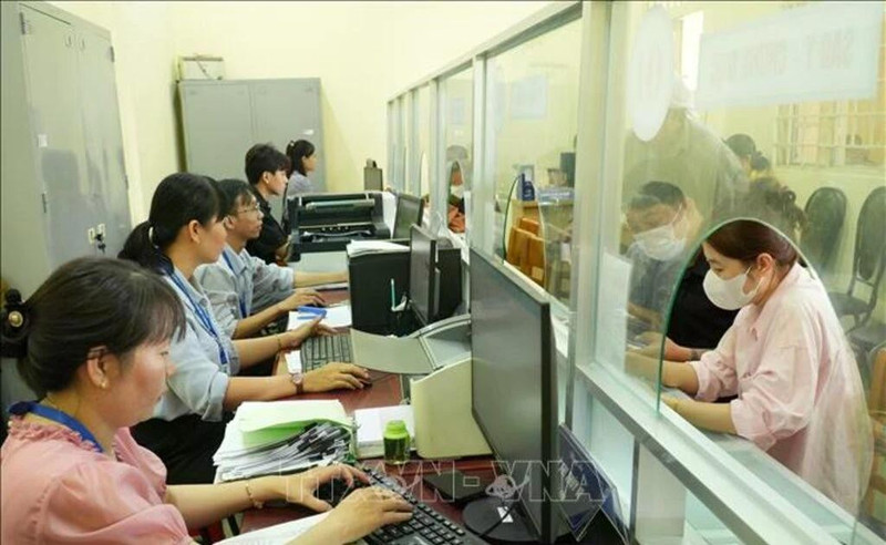 胡志明市泰美乡干部、公务员为群众办理行政手续。