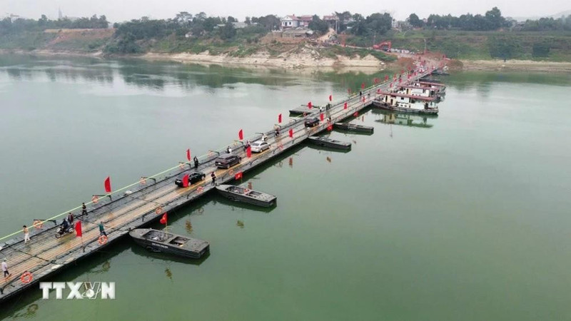 车辆和人民群众在横跨泸江浮桥上出行。