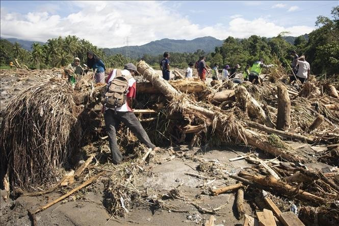 印尼西苏门答腊发生洪水和山体滑坡后，救援力量在现场搜寻遇难者。