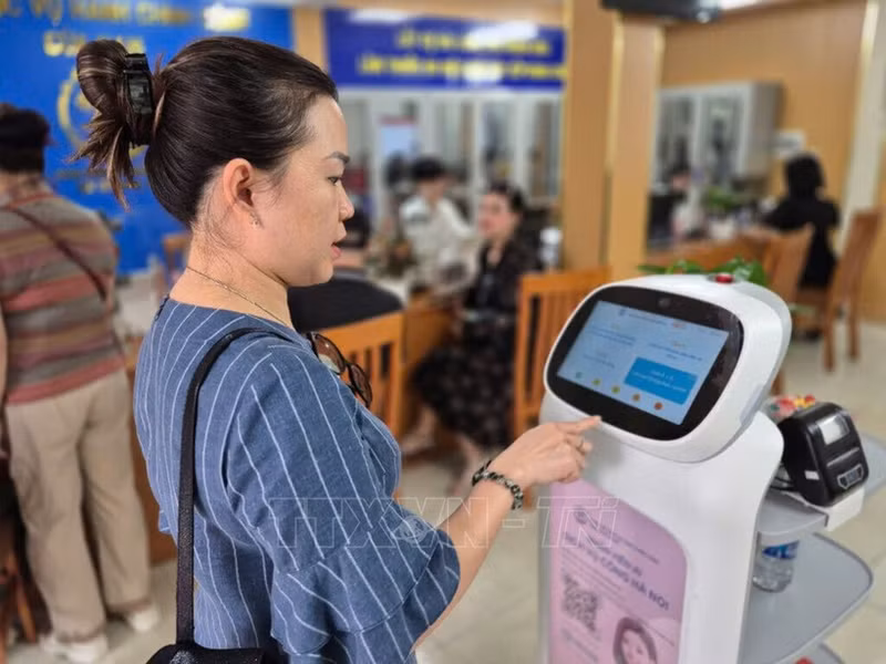 人民体验河内市南门坊人工智能机器人服务。
