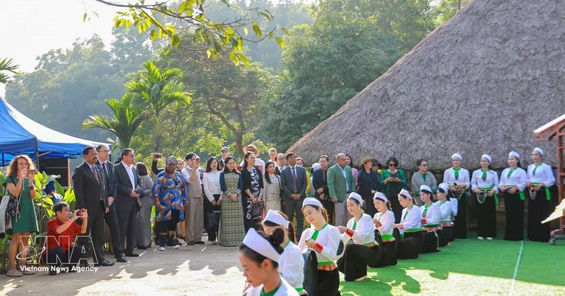 越南各民族文化旅游村的芒族同胞向游客推介本民族文化特色。