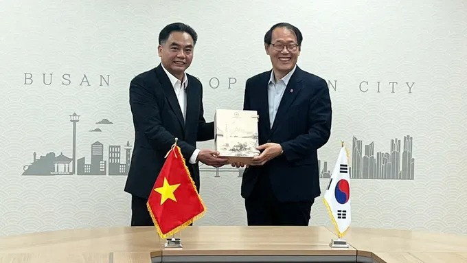 胡志明市人民委员会副主席阮禄河和韩国釜山市副市长李俊承。
