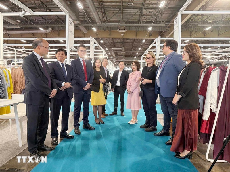 越南驻法国大使丁全胜与参加展览的越南企业代表交流。