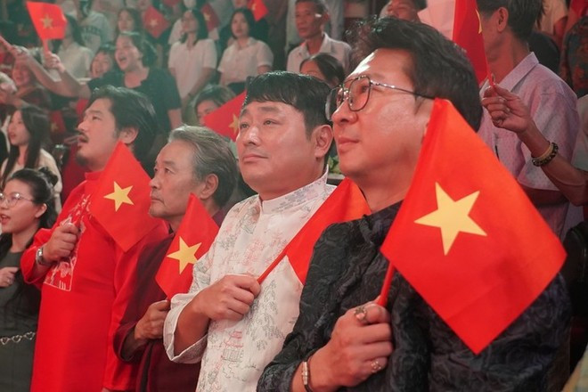韩国制作团队身着奥黛,手持越南国旗观看演出。(图片来源:越南话剧院供图) banhmi.jpg