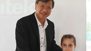 越南驻古巴大使黎光龙向一名获奖学生颁发奖状。（图片来源：越通社）