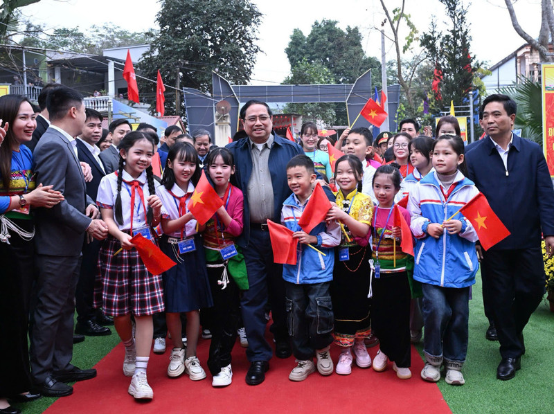 政府总理范明正与清化省锦石一贯制学校师生合影留念。