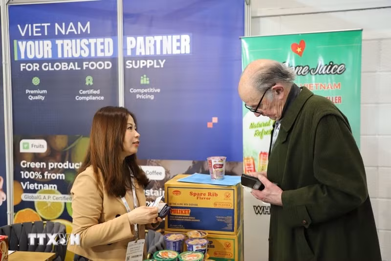 越南驻英国商务处代表向国际客户介绍越南企业产品。（图片来源：越通社）