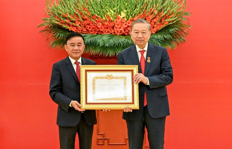 越共中央书记处常务书记陈锦秀向越共中央总书记苏林授予45年党龄纪念章。