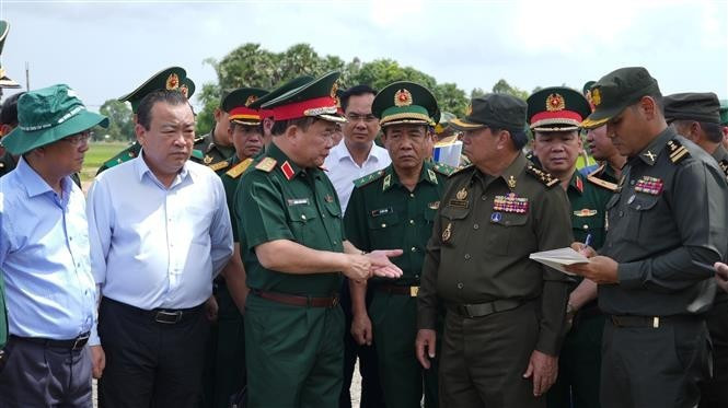 越南国防部副部长黄春战中将（左三）与柬埔寨皇家陆军副总司令伊萨拉将军（右二）讨论在柬埔寨柴桢省柴桢县建设桑索瓦纳小学友谊项目计划。（图片来源：越通社）